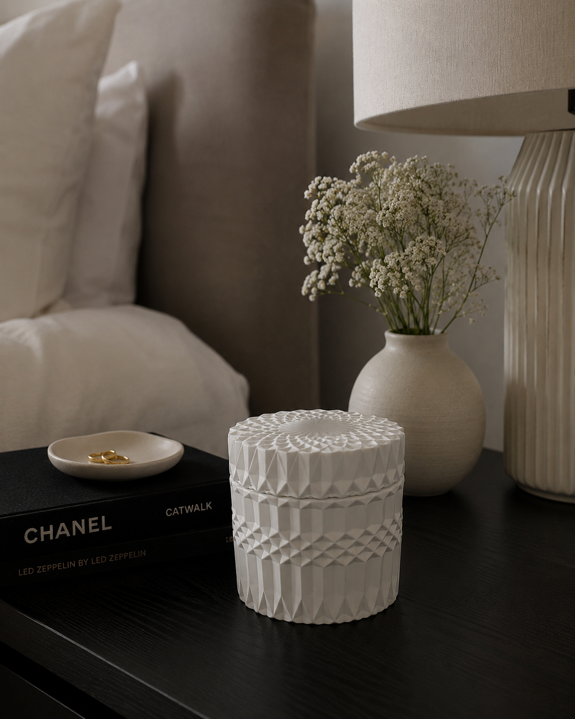 Ripple Vessel styled as a decorative object on a dark nightstand beside a small jewelry dish and baby's breath flowers